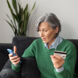 middle-aged woman surprised and concerned looking at bank account
