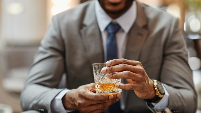 Handsome, successful Black businessman in suit with cocktail
