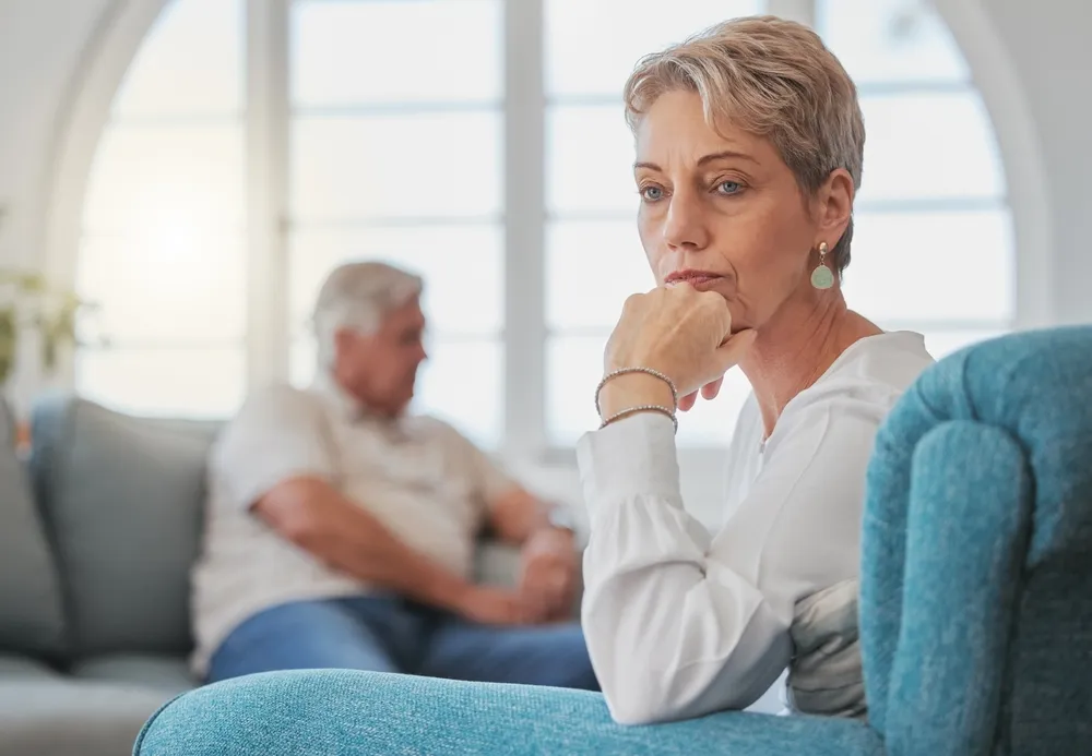 Unhappy senior couple on couch fighting or having an argument