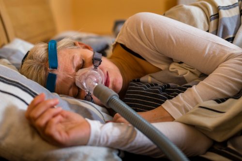 woman using cpap machine to stop choking and snoring from obstructive sleep apnea