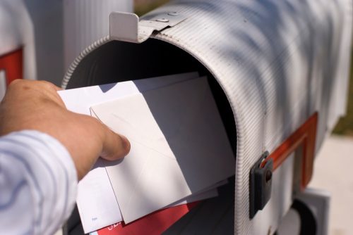 Male human hand getting the mail