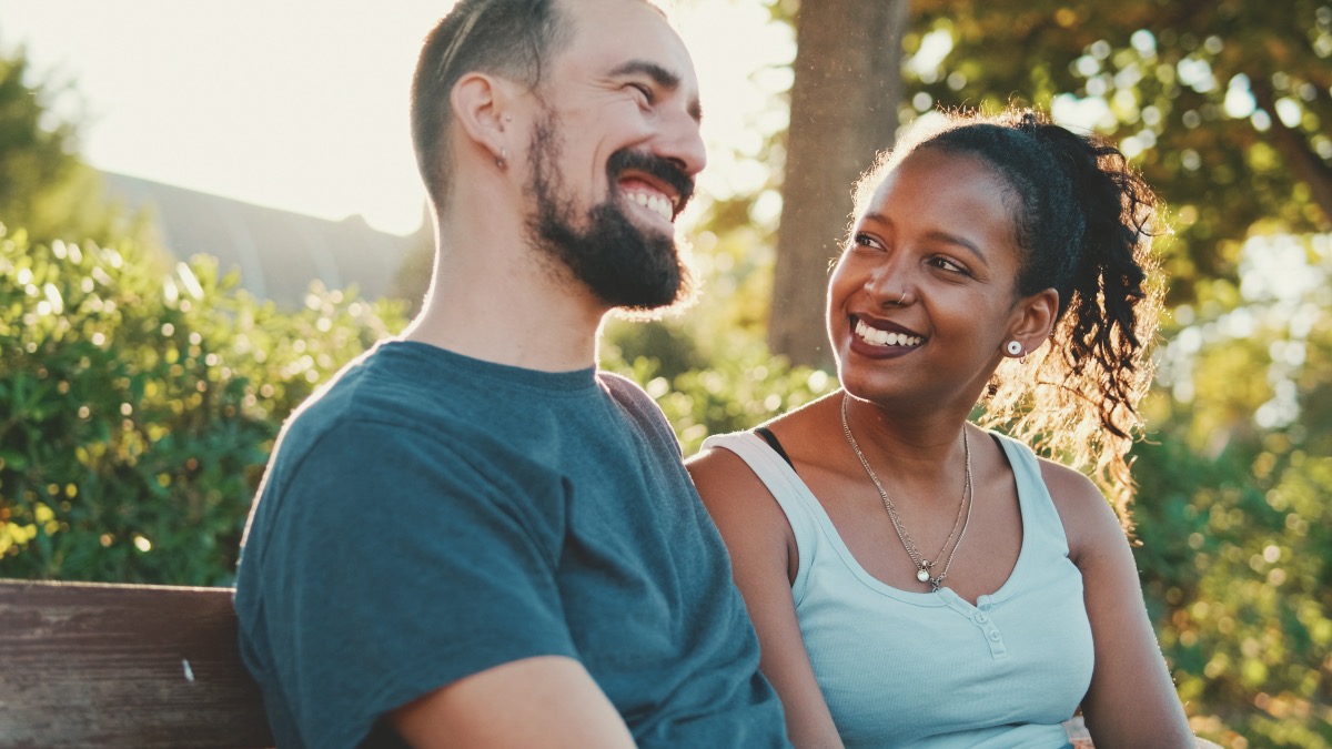 man and woman talking on a park bench