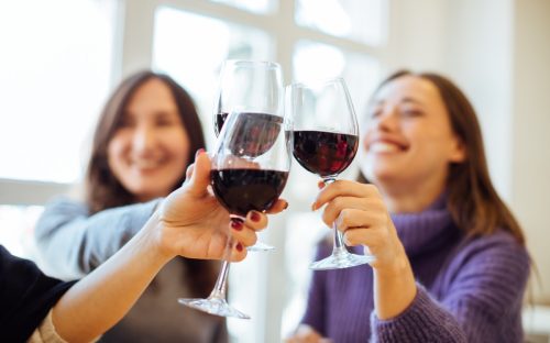 Group of women drinking red wine while playing truth or drink