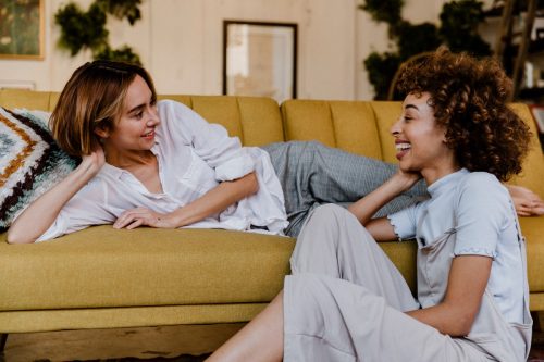 two women smiling and talking in the living room