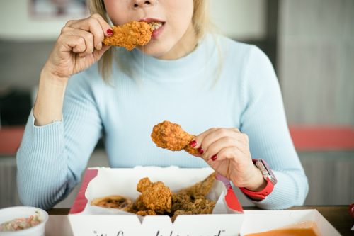 Woman eating fried chicken.