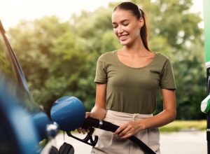 woman smiling while filling gas