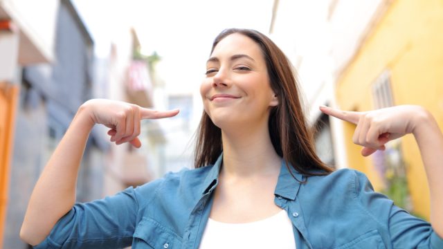 Girl Smiling and Pointing to Herself