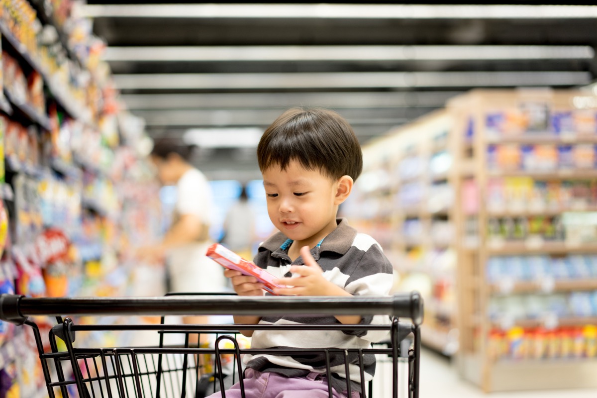 A boy is shopping with his mom in a supermarket.