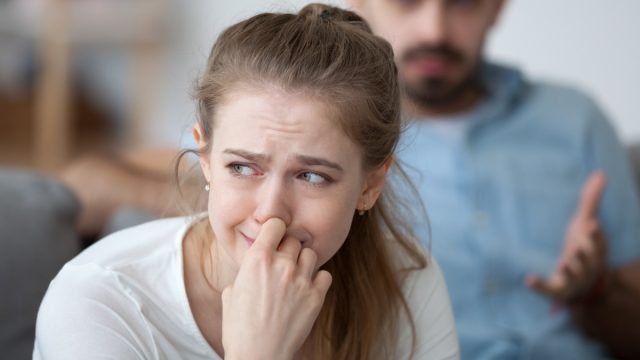 Stressed woman crying feeling depressed offended by controlling husband tyrant blaming wife of problems in unhappy marriage, sad girl in tears worried about family fight and relationships problems