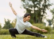 Portrait of serious woman wearing sport clothes training, practicing wushu in park. Healthy lifestyle, kungfu, martial arts concept