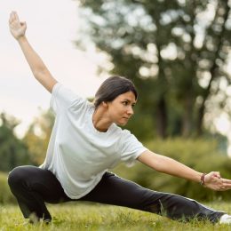 Portrait of serious woman wearing sport clothes training, practicing wushu in park. Healthy lifestyle, kungfu, martial arts concept