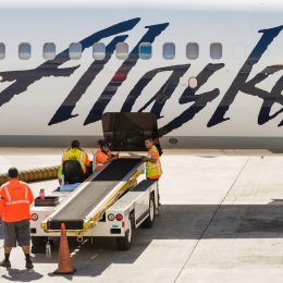 A group of Alaska Airlines baggage handlers taking a break mid day on the tarmac at the Honolulu airport.