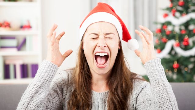 Angry woman in santa cap screaming