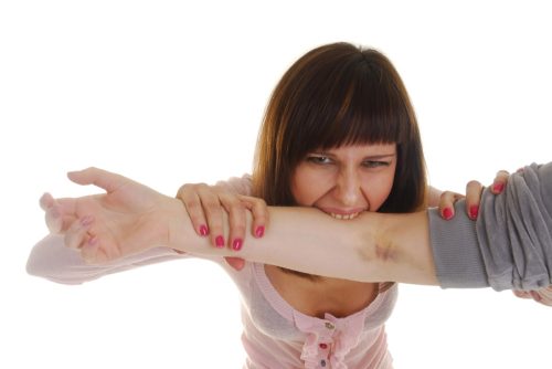 young woman biting someone's arm