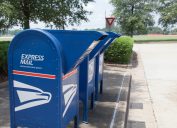 A trio of blue express mail mailboxes on a street