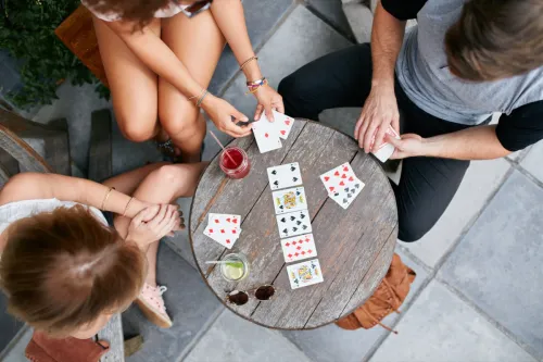 group of friends playing drinking games involving cards while out at a bar