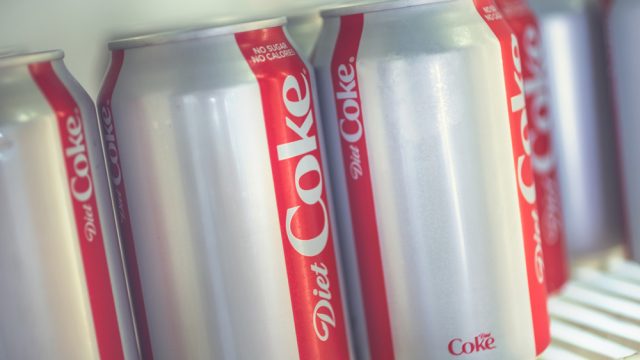 A close up of Diet Coke cans in a fridge