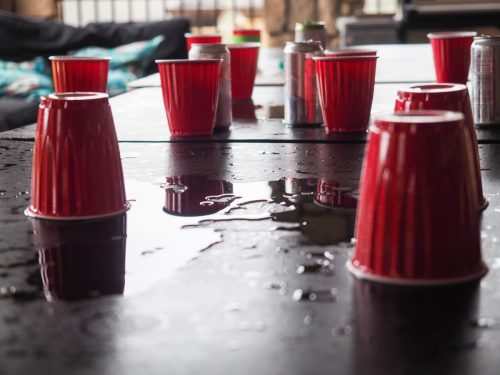 plastic beer cups on an empty table following a game of beer pong