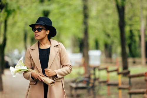 fashionable woman wearing camel coat and hat