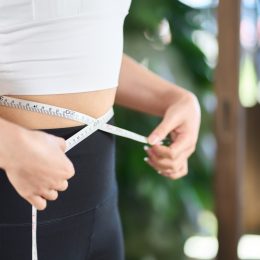 woman measuring herself for weight loss