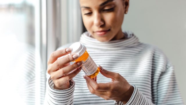 woman looking at prescription medication