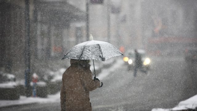 man walking with umbrella in a winter storm