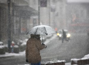 man walking with umbrella in a winter storm