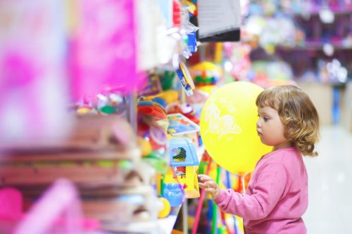 Toddler kid at the mall, choosing toys, lifestyle