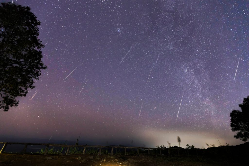 The trail of meteors during a meteor shower in the night sky