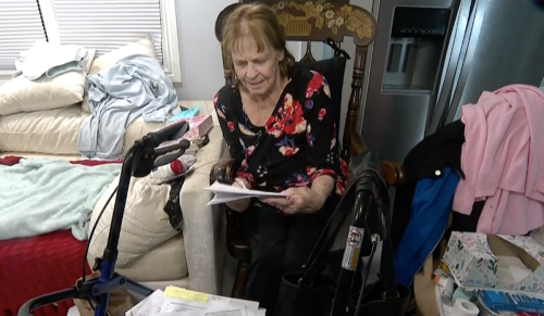 Mary Smith sitting in rocking chair and looking through paperwork