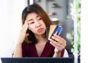 woman having problem with debt ,over spending money from shopping hand holding credit card and worry about late , deadline payment