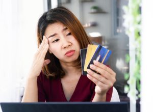 woman having problem with debt ,over spending money from shopping hand holding credit card and worry about late , deadline payment