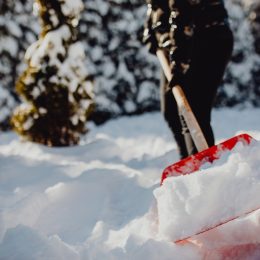 Public service worker or citizen shoveling snow during heavy winter blizzard