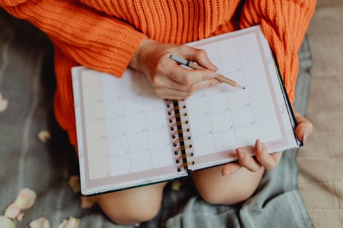 Woman writing in planner or calendar