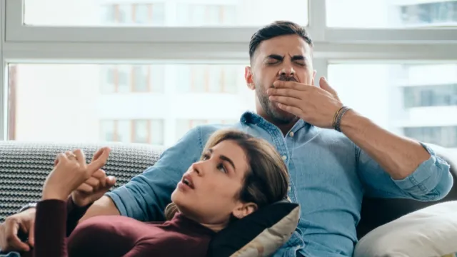 man yawning and interested in partner