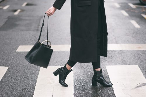 woman crossing street in all-black outfit