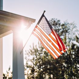 american flag flying outside of typical home