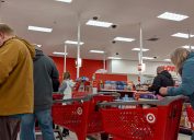 A line of customers with shopping carts at a Target store.