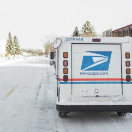 Moorhead, Minnesota, United States - January 16, 2016: USPS, United States Postal Service, van parked on suburban street during winter with lots of snow.