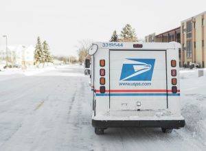Moorhead, Minnesota, United States - January 16, 2016: USPS, United States Postal Service, van parked on suburban street during winter with lots of snow.
