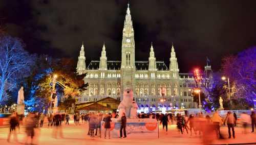 Austria's Wienereistraum ice skating rink at night with Vienna City Hall in the background.