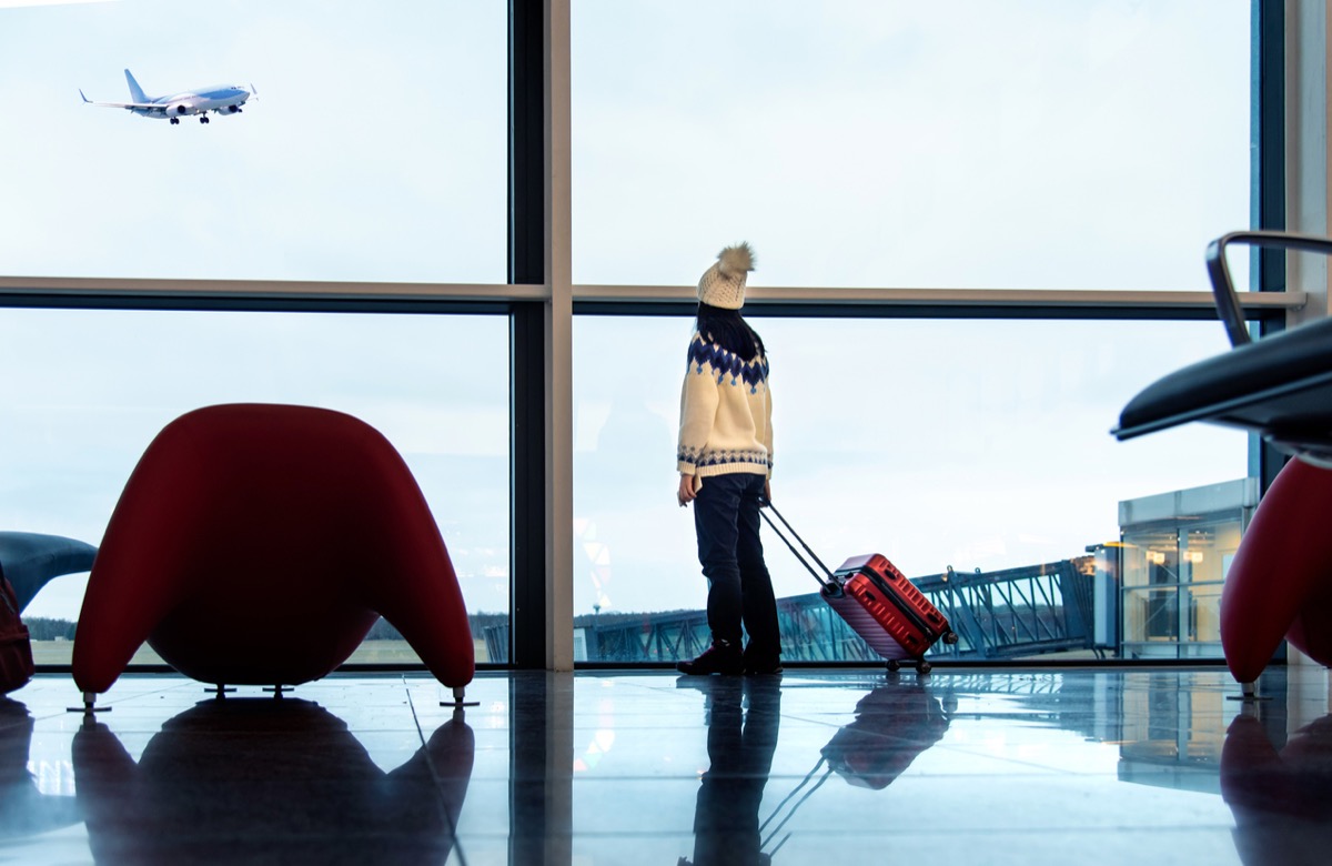 Girl waiting at the airport with suitcase