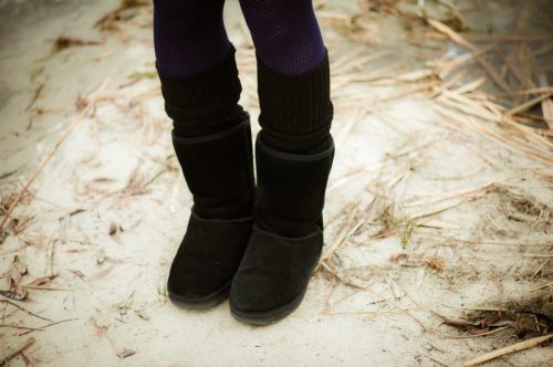 Womans legs wearing black Ugg boots and tights