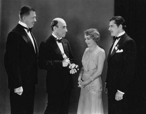 Hanns Kraly, William C. DeMille, Mary Pickford, and Warner Baxter at the 1930 Academy Awards