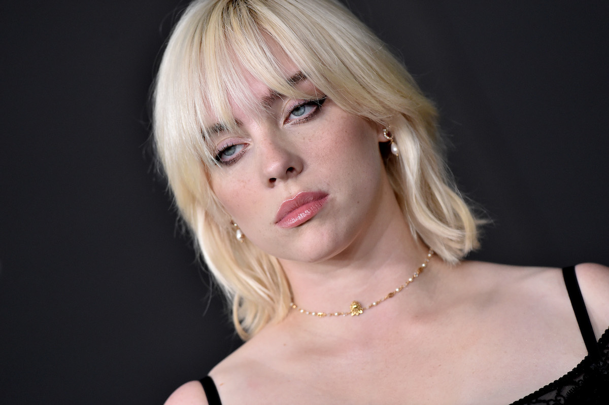 Billie Eilish with blonde hair and a wolf cut wearing a black top