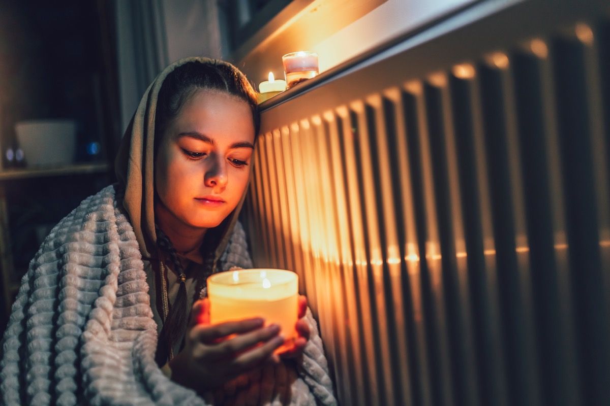 Widespread Blackouts Predicted For 2024 Best Life   Girl Keeping Warm In Power Outage 