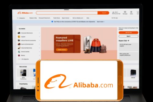 Alibaba company logo displayed in mobile screen and their website displayed in blurred computer screen.
