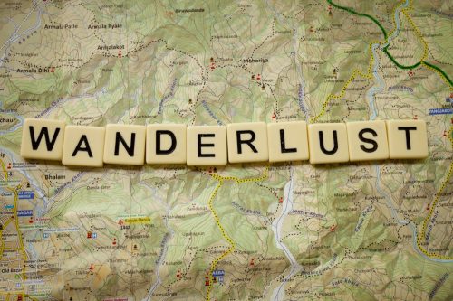 wanderlust spelled out in block letters over a map