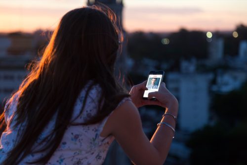 woman on a mobile dating app during sunset