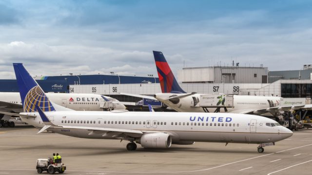 Two Delta planes at the gate while a United plane taxis behind them